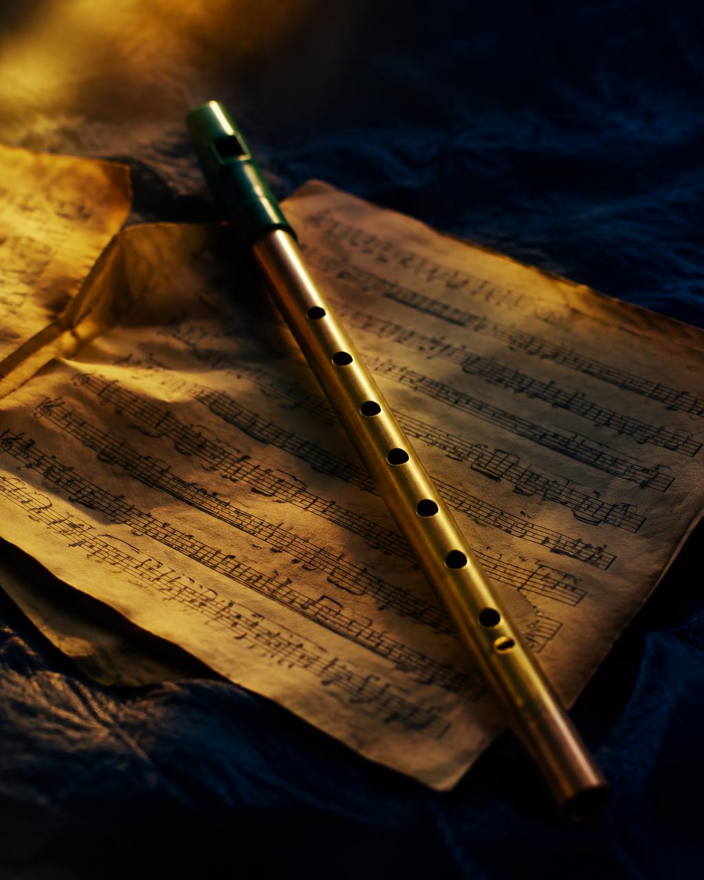 A tin whistle resting on sheet music
